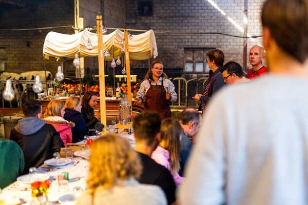 Groep luistert naar de uitleg van de chef-kok tijdens een barbecue workshop bij Buiten Eten in Someren