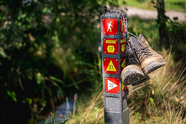 Wanderschuhe hängen an einem Wanderwegpfosten in der Gemeinde Roermond