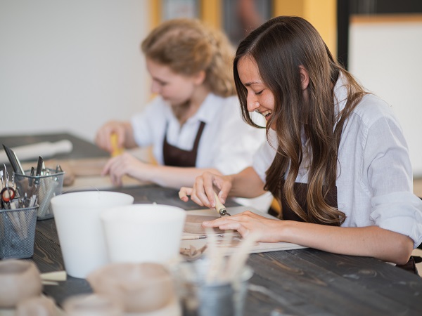 twee meiden werken aan een project met klei